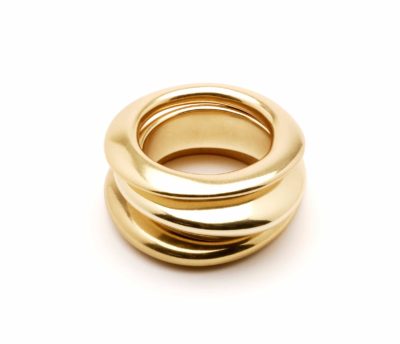 Un objet sculptural en or poli composé de trois boucles arrondies interconnectées. La pièce a une surface lisse et réfléchissante, créant une apparence élégante et luxueuse rappelant le chic parisien. Cette forme dynamique et fluide serait un sujet captivant pour tout photographe ayant un œil pour l'art inspiré de la mode.