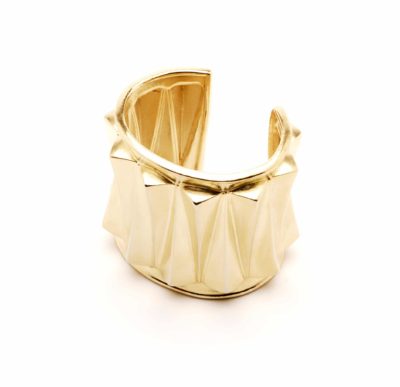 Un bracelet manchette géométrique épais en or avec une finition brillante et un motif à facettes. Le design présente des plis angulaires en 3D, ce qui lui confère un aspect contemporain et sculptural. Le bracelet manchette ouvert permet un port facile, parfait pour celles qui apprécient la sensibilité mode avant-gardiste de Thomas Duclert.